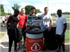 Guys pose with Recycle Cans and Bottles sign